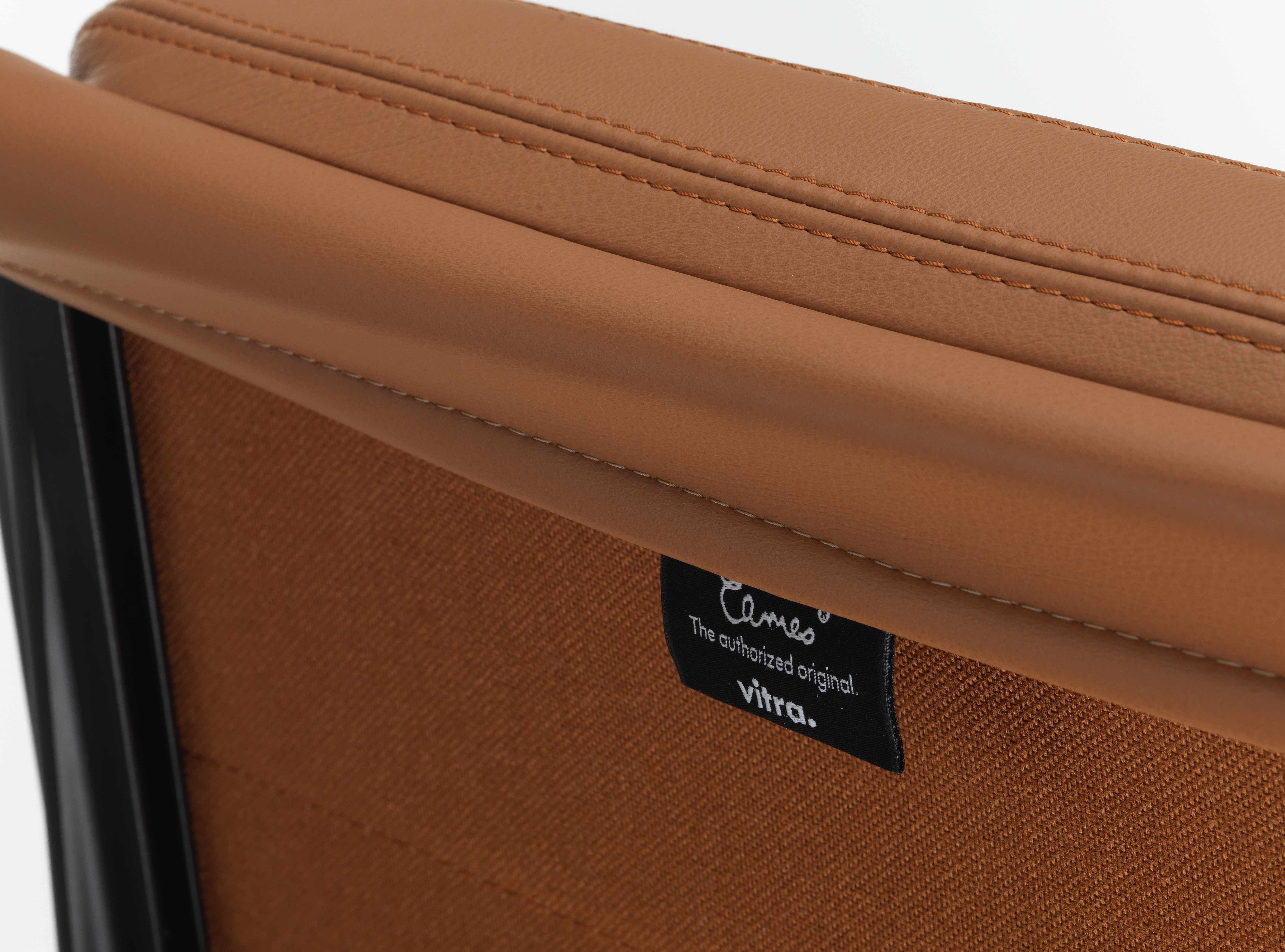 Detailaufnahme des Soft Pad Chair EA222 von Vitra mit braunem Leder und feinen Ziernähten.