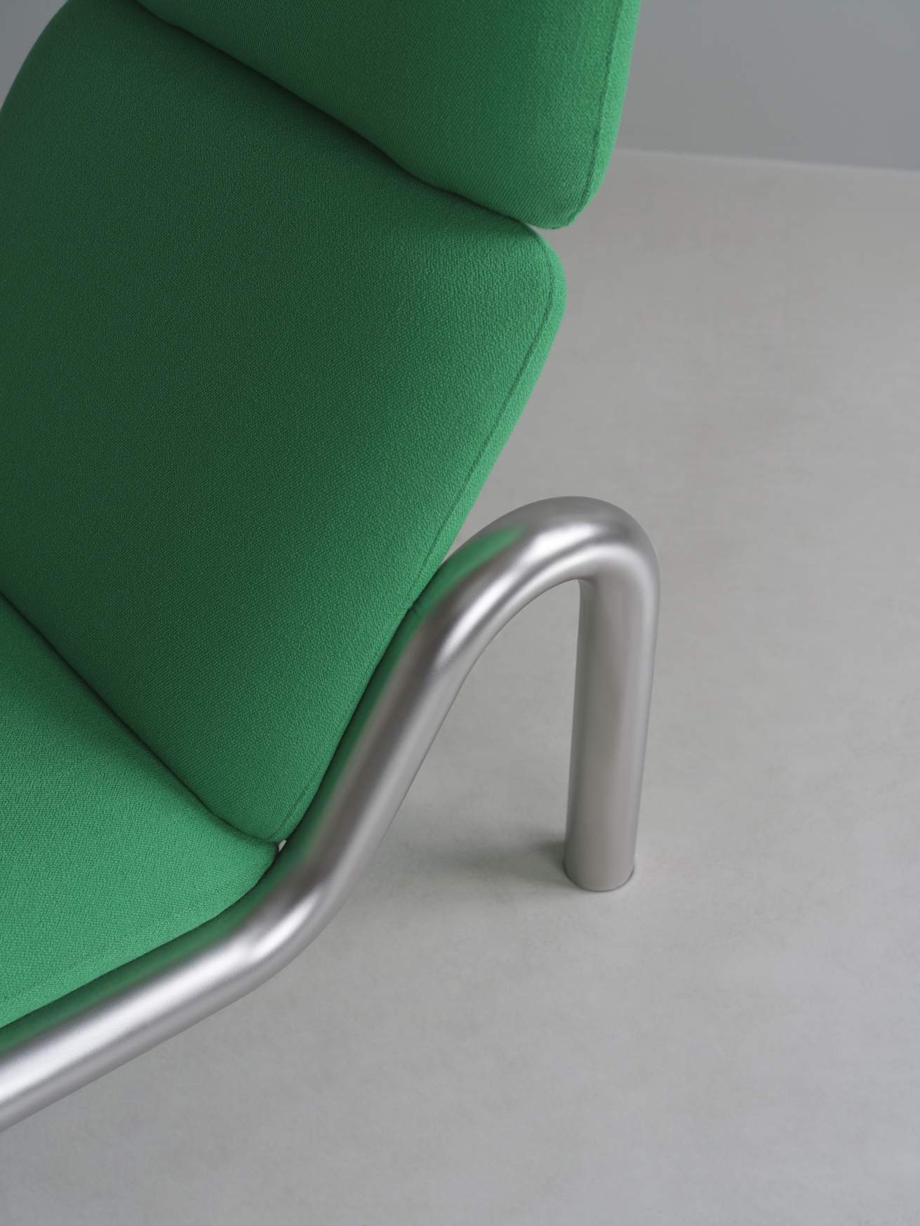 Detailaufnahme des grünen Tube Lounge Chair Sessels von Normann Copenhagen mit silbernem Metallgestell.
