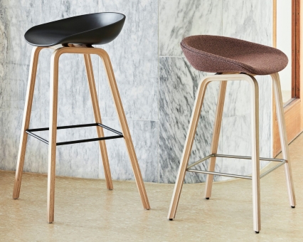 Zwei moderne Barhocker mit Holzbeinen, einer mit schwarzem, der andere mit braunem Sitz.