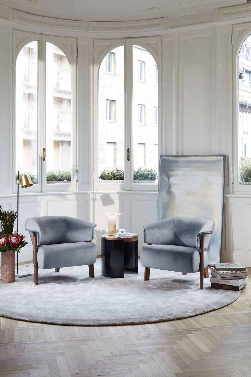 Zwei graue Back-Wing Sessel von Cassina in hellem Raum mit rundem Teppich.