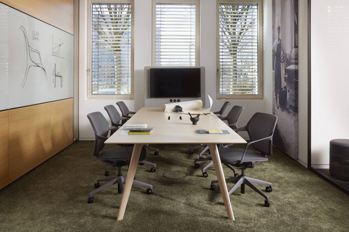 Ray Work 9220 von Brunner: Moderner Konferenzraum mit hellem Holztisch und ergonomischen Bürodrehstühlen in Grau.