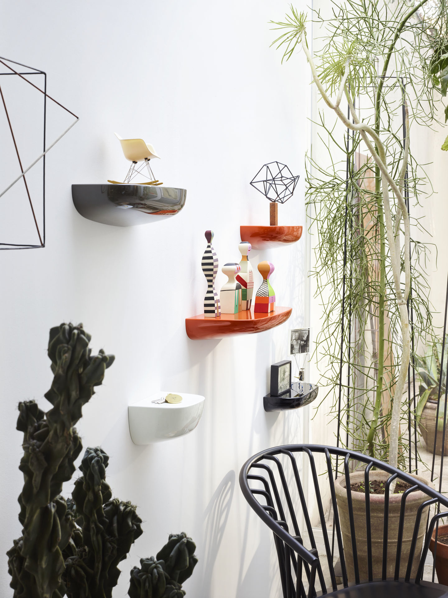 Mehrere farbige Vitra Corniches Wandboards in unterschiedlichen Größen an einer weißen Wand mit Dekoration.