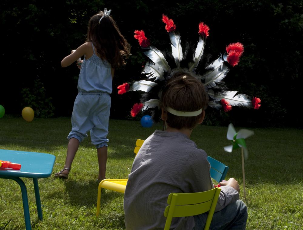 Kinder spielen im Garten mit Fermob Luxembourg Kinderstühlen und Tisch im Freien.