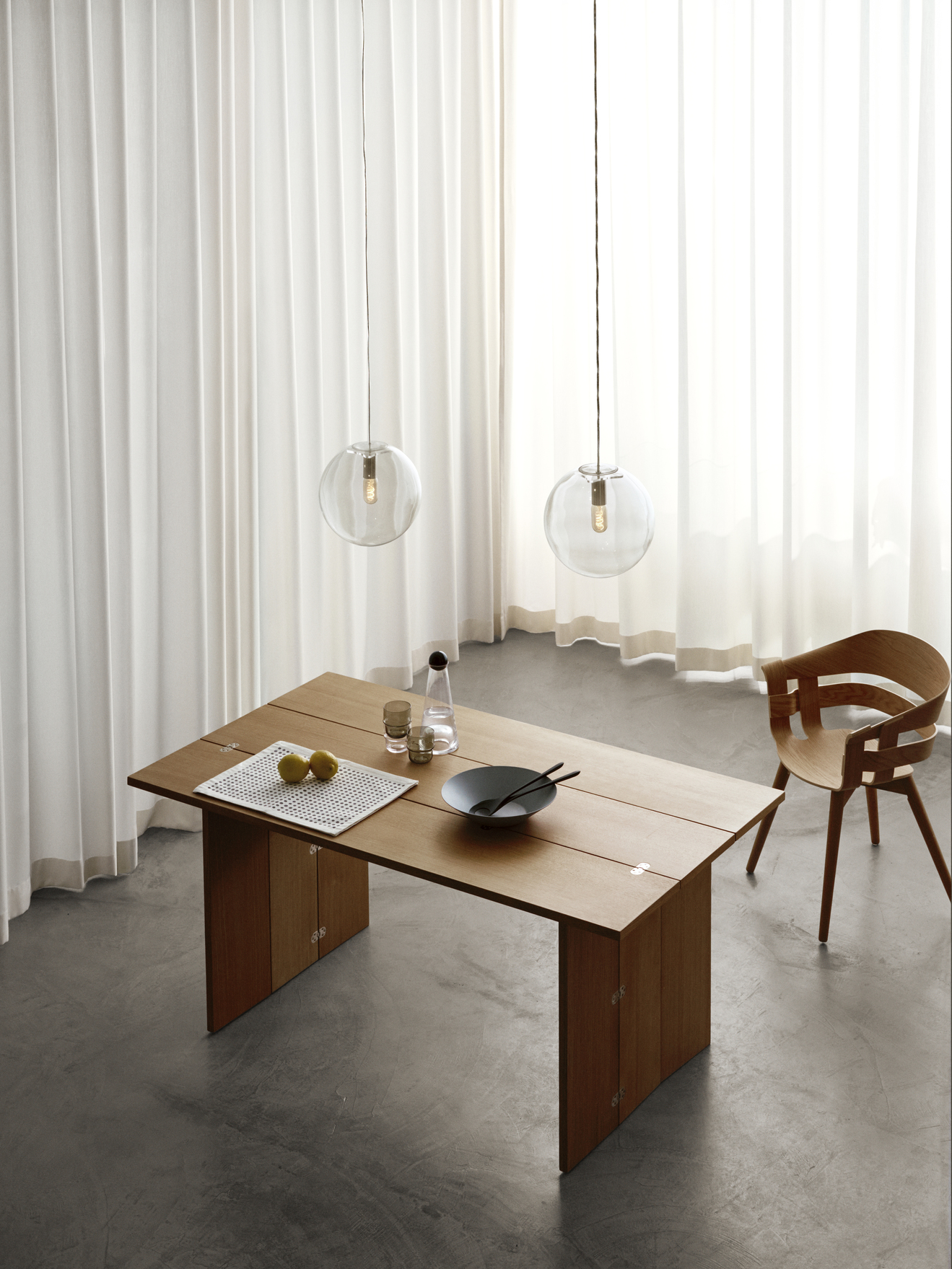 Design House Stockholm Flip Table Klapptisch aus Holz, gedeckt mit Geschirr und Zitronen, neben Holzstuhl.