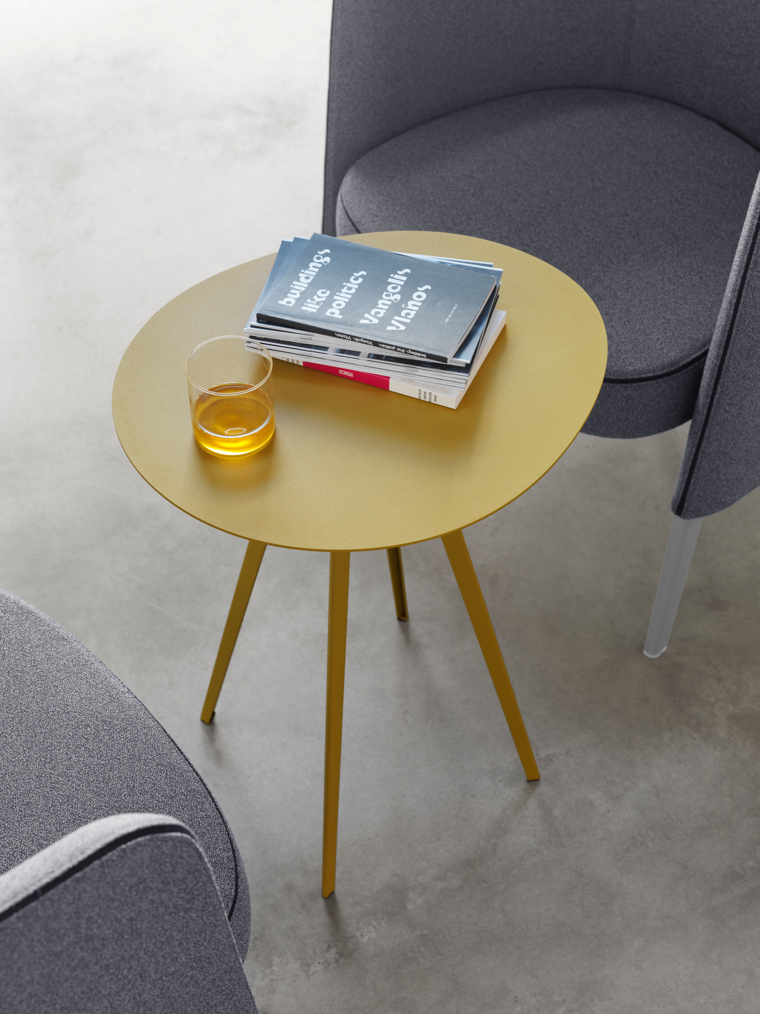 Senffarbener Agorà Beistelltisch von Segis, runde Tischplatte mit Getränk und Zeitschriften, modernes Design.