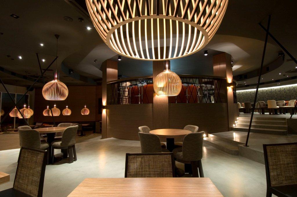 Innenaufnahme eines Restaurants mit mehreren Octo Pendelleuchten von Secto Design aus hellem Holz.