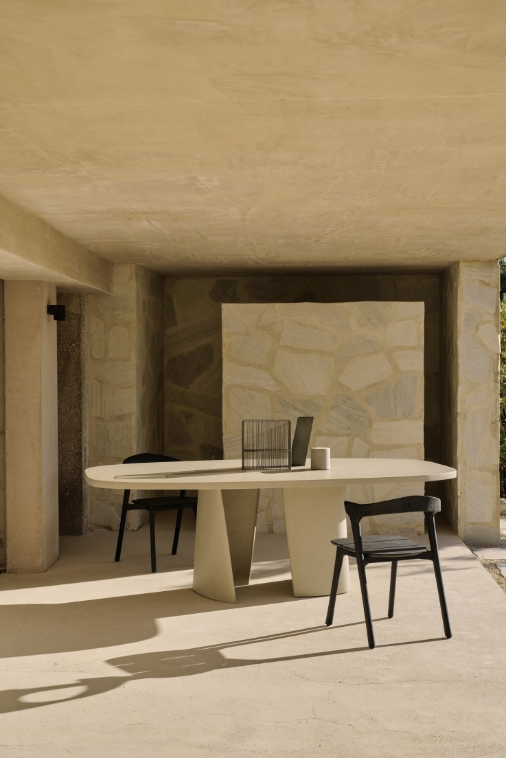 Canyon Esstisch von Ethnicraft, ein moderner Outdoor Tisch aus Beton mit zwei schwarzen Stühlen.