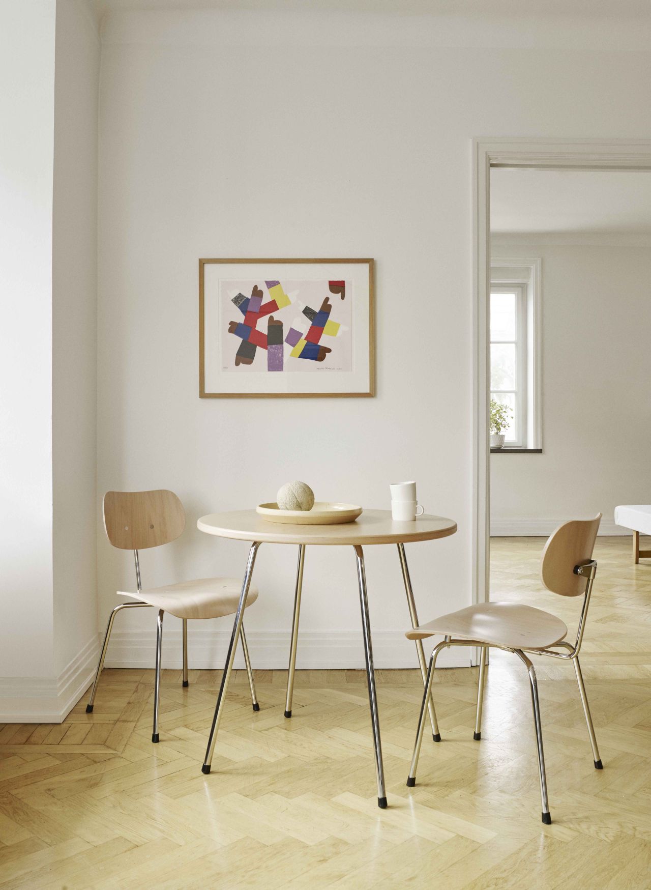 SE 330 Cafétisch von Wilde+Spieth mit zwei Stühlen in hellem Raum. Designklassiker für Esszimmer.