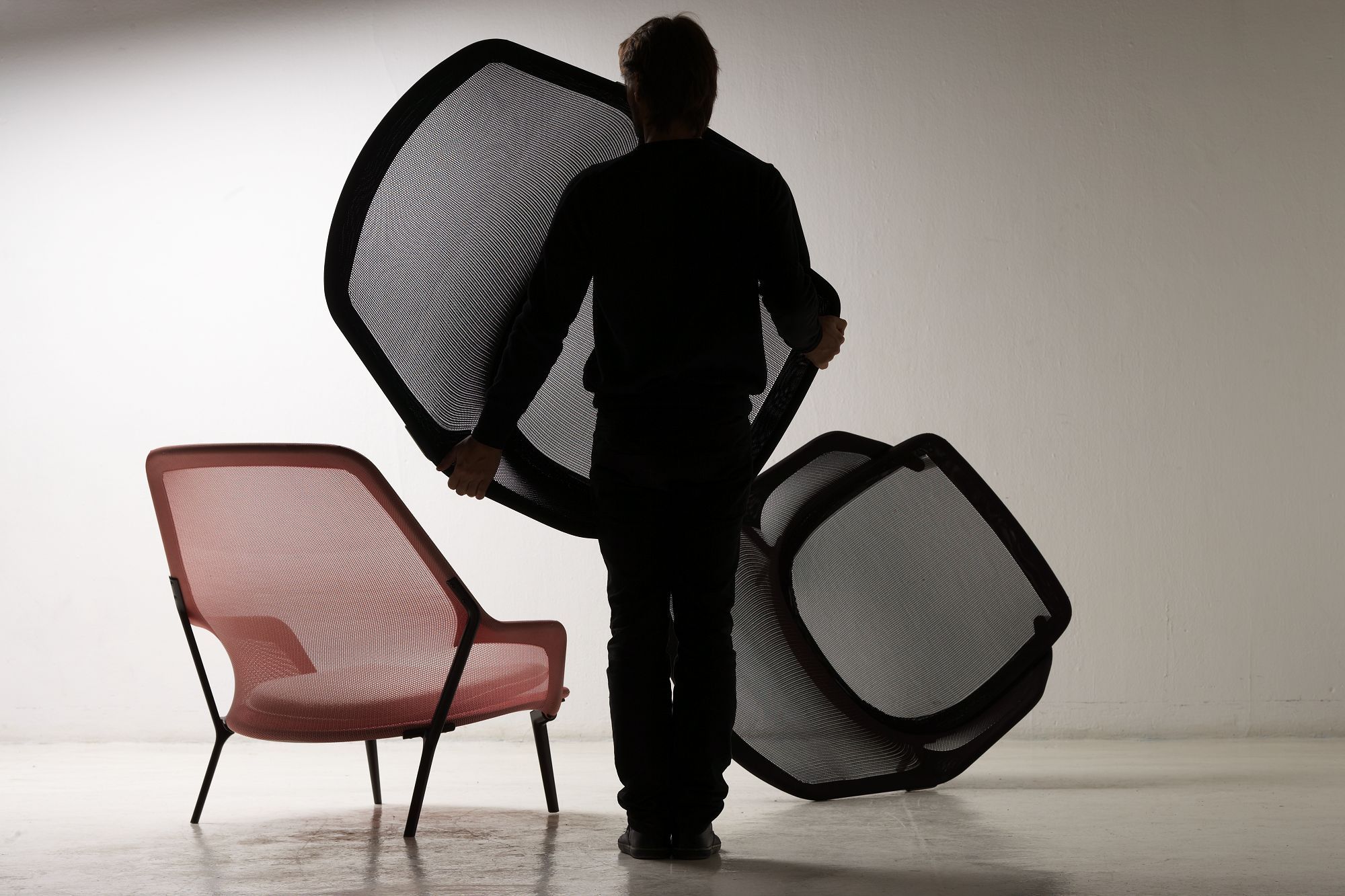 Vitra Slow Chair Sessel in Rot mit Person, die weitere Sesselteile trägt, für Montage.