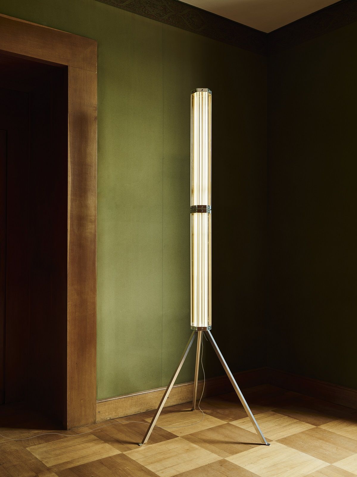 Superwire Stehleuchte von Flos: Moderne Stehlampe mit vertikalen Leuchtstoffröhren und silbernem Stativfuß in einem stilvollen Interieur.