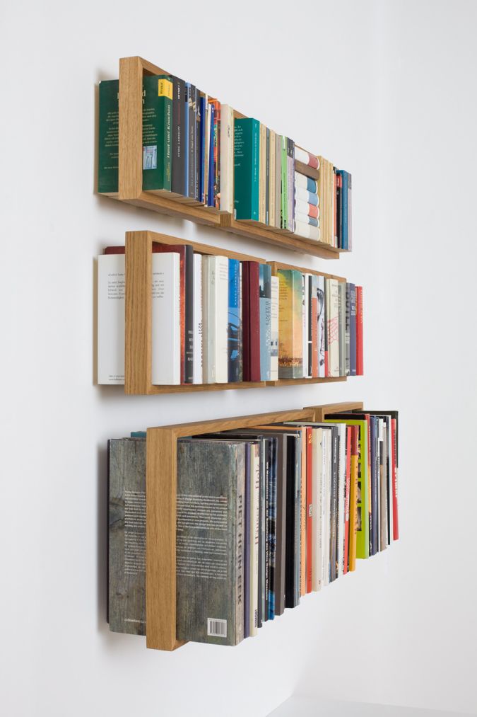 Nahaufnahme von drei schwebenden, mit Büchern gefüllten Regalen b Eiche, modernes Wandregal Design.