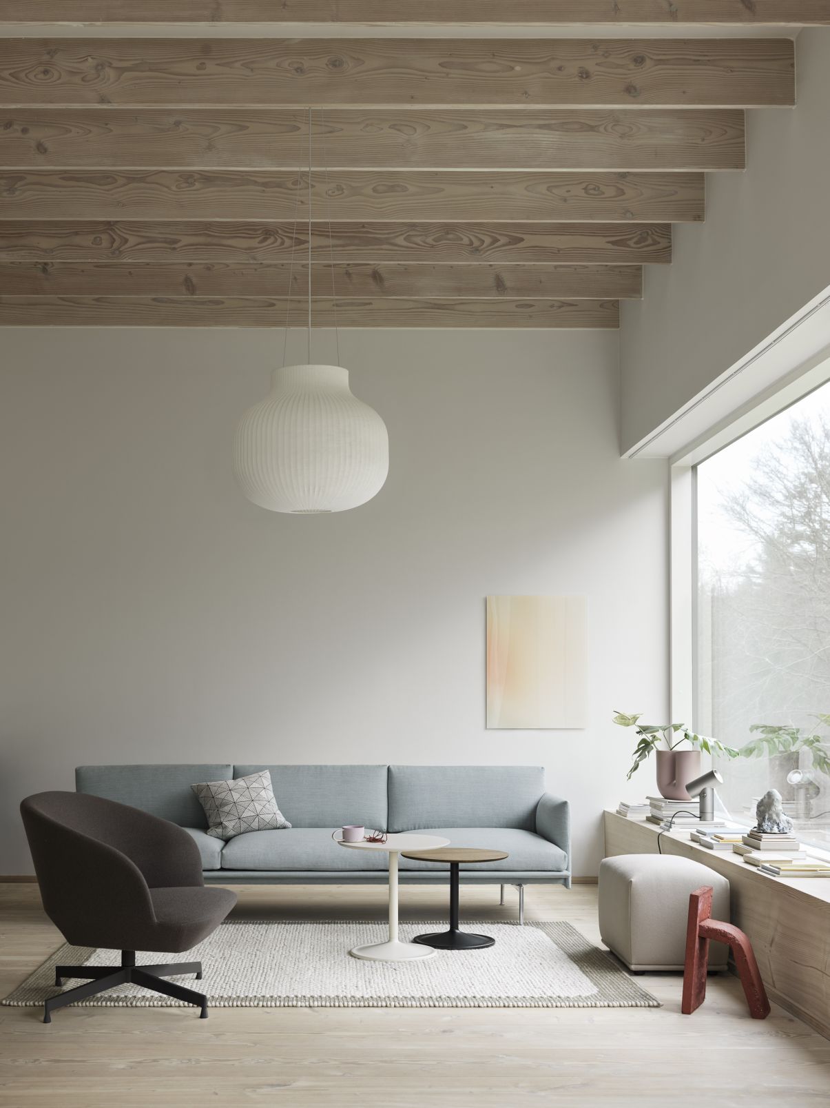 Wohnzimmer mit Oslo Lounge Chair Sessel von Muuto, Sofa, Teppich und Beistelltischen.