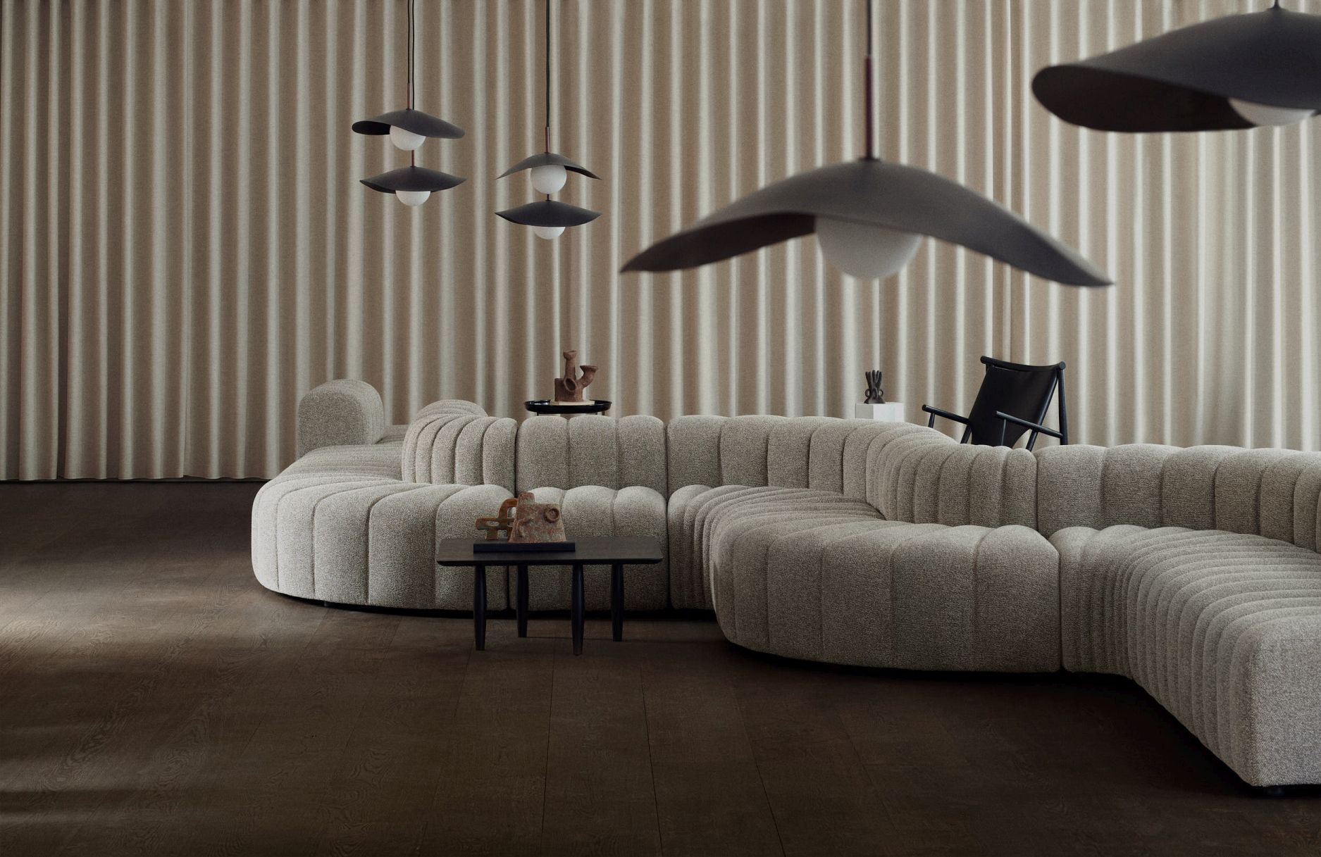 Fuji Pendelleuchten von Norr11 über modernem Wohnzimmer mit grauem Sofa und Vorhängen.