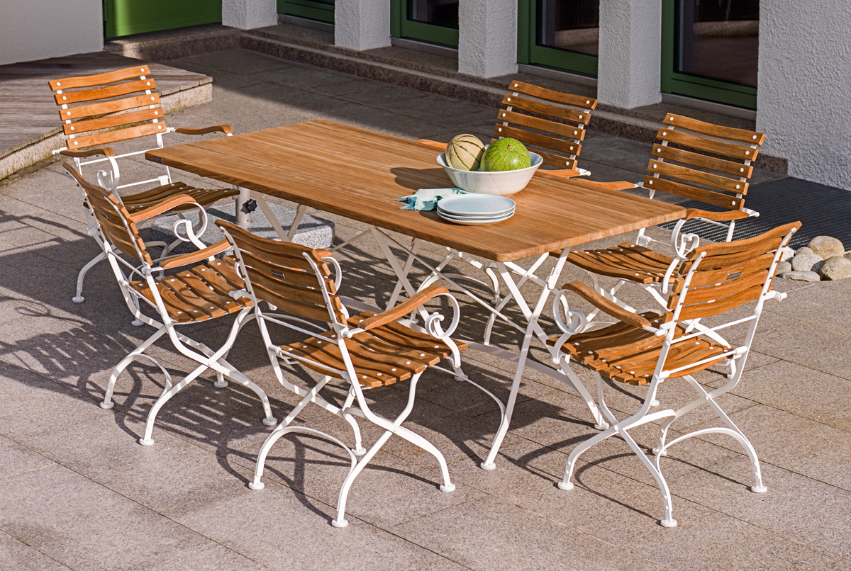 Weishäupl Classic Armchair Sessel, klappbar, mit Armlehnen und Gartentisch auf einer Terrasse.