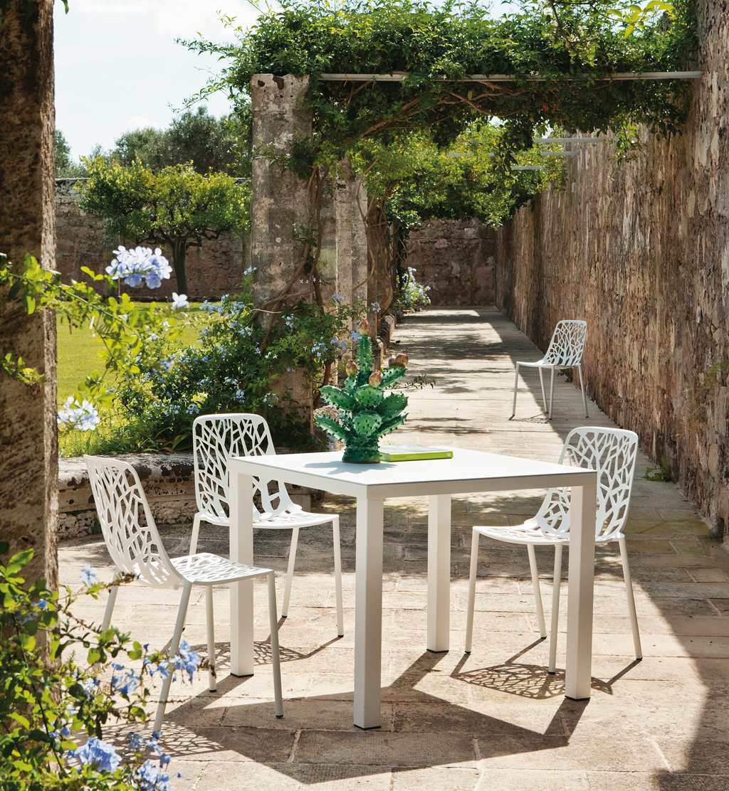 Weißer Easy Outdoor Tisch mit Stühlen im Garten, ideal für entspannte Stunden im Freien.