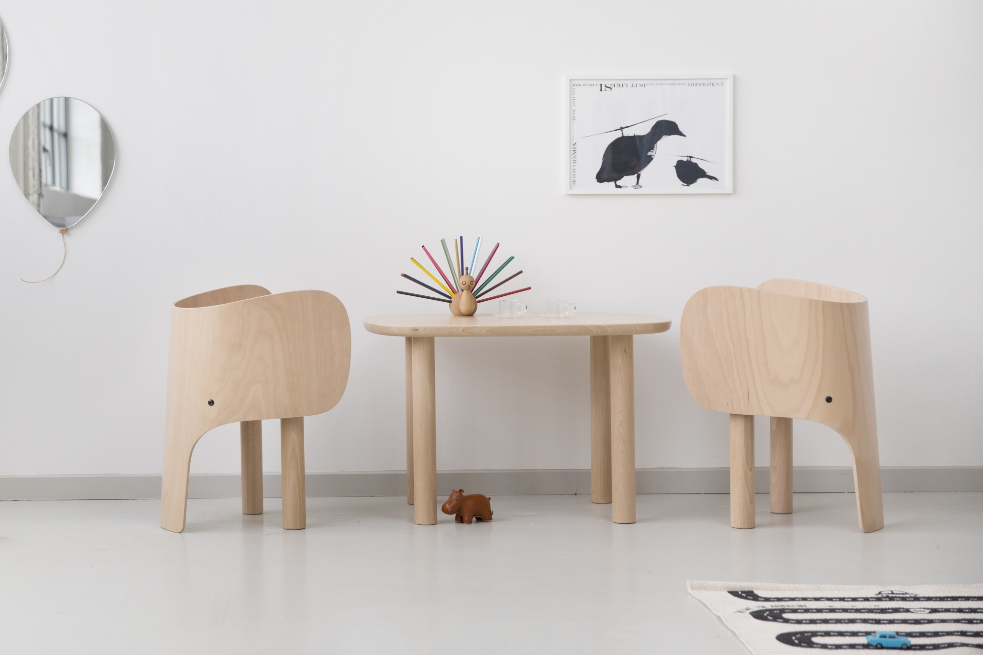 Zwei EO Elephant Chairs Kinderstühle aus Holz und ein passender Tisch in einem Kinderzimmer.