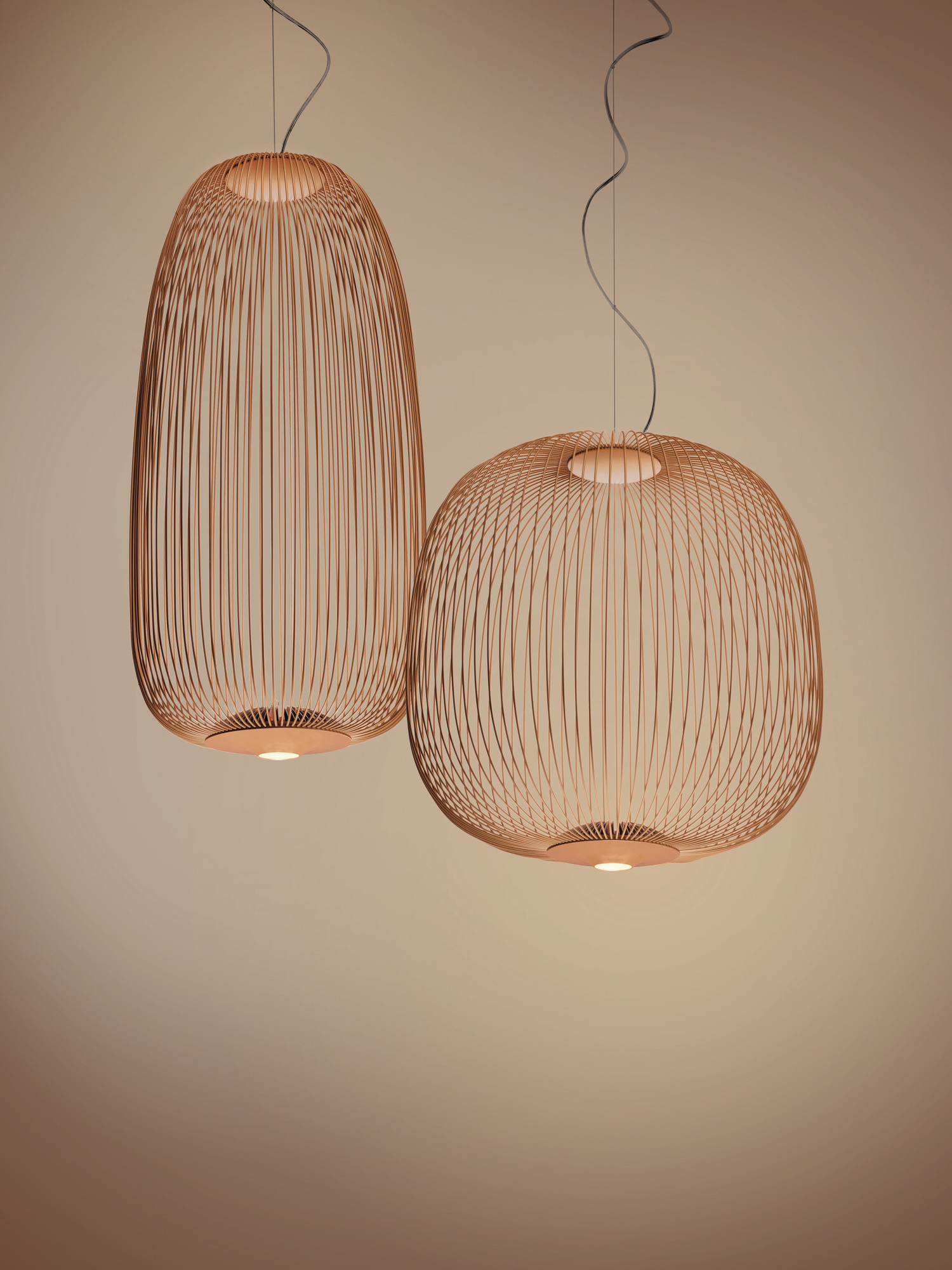 Zwei Foscarini Spokes Pendelleuchten aus Kupfer, modernes Design mit filigranen Metallstreben.