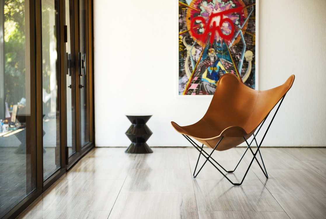 Pampa Mariposa Butterfly Chair Sessel aus braunem Leder mit schwarzem Metallgestell im modernen Wohnraum.