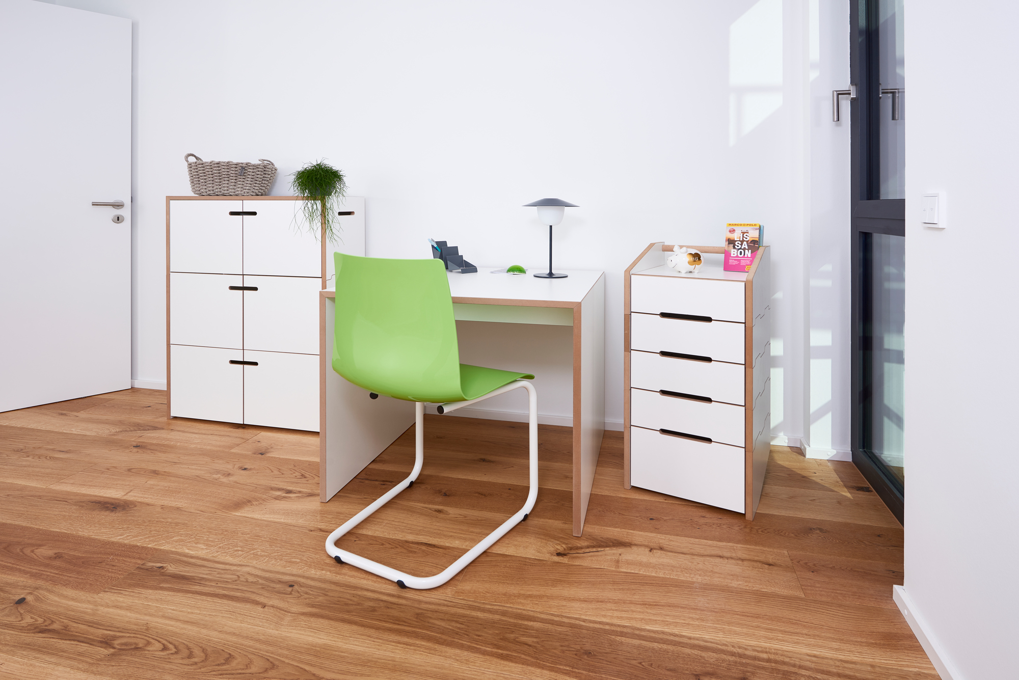 Tojo Hochstapler Regal Grundmodul mit Türen in weiß und Holz mit Schreibtisch und Stuhl.