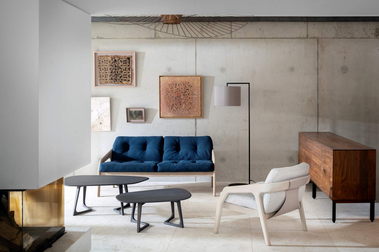 Blaues Friday 2 Sofa, ein moderner 2-Sitzer von Zeitraum, in stilvollem Wohnzimmer mit Betonwand.