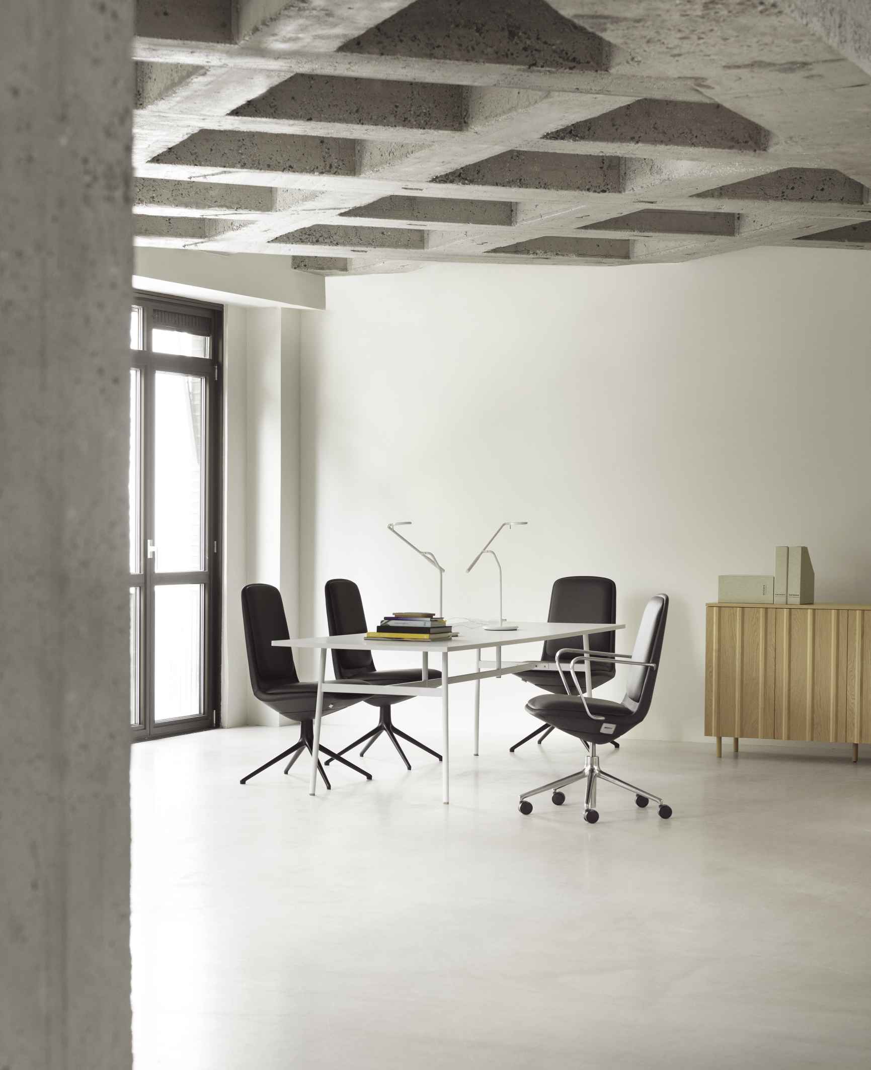 Off Chair Low Konferenzstuhl von Normann Copenhagen in modernem Büroambiente. Schwarze Bürostühle am Tisch.