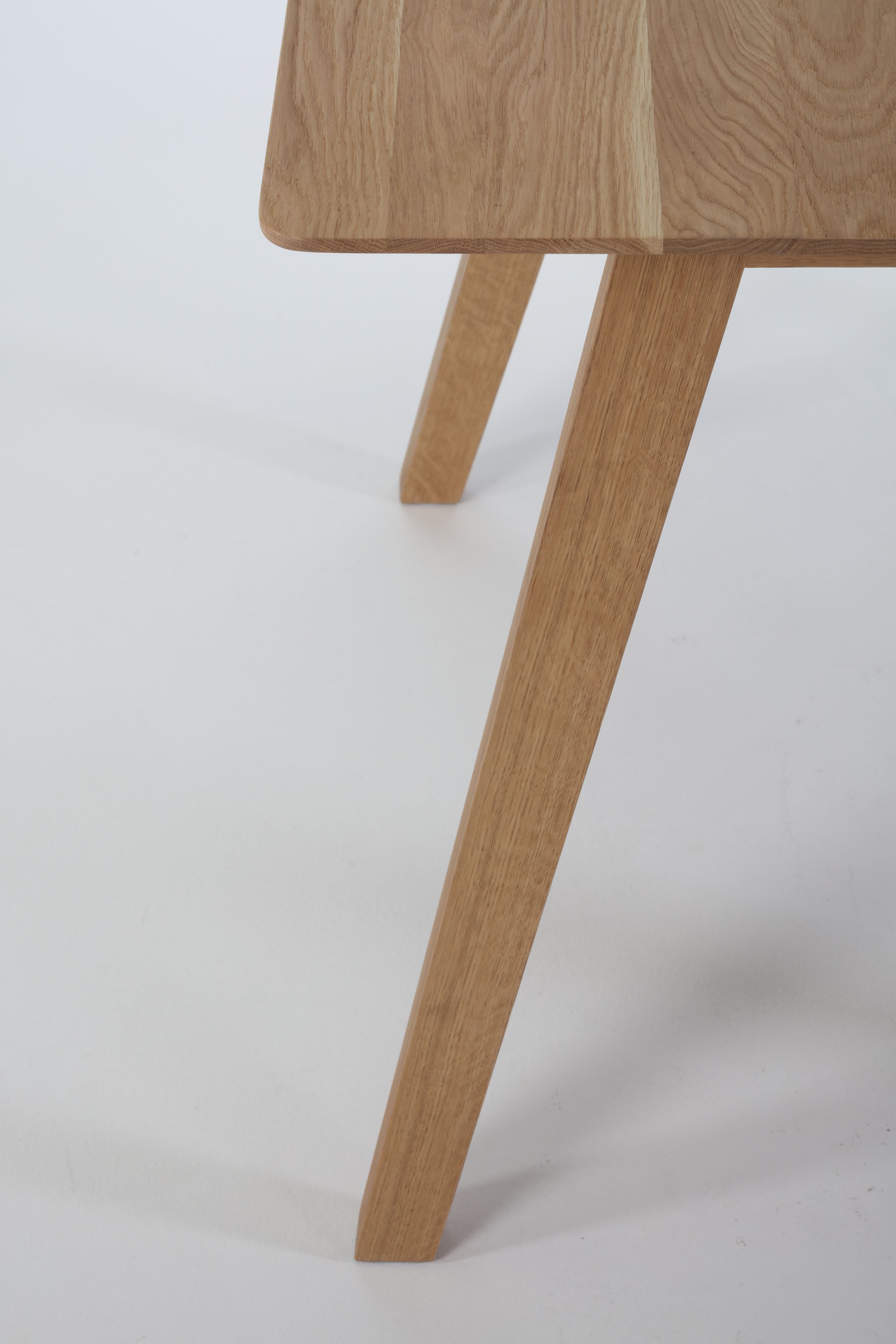 Detailaufnahme des Monk Tisches von Prostoria, Fokus auf die Tischplatte und die Tischbeine aus hellem Holz.