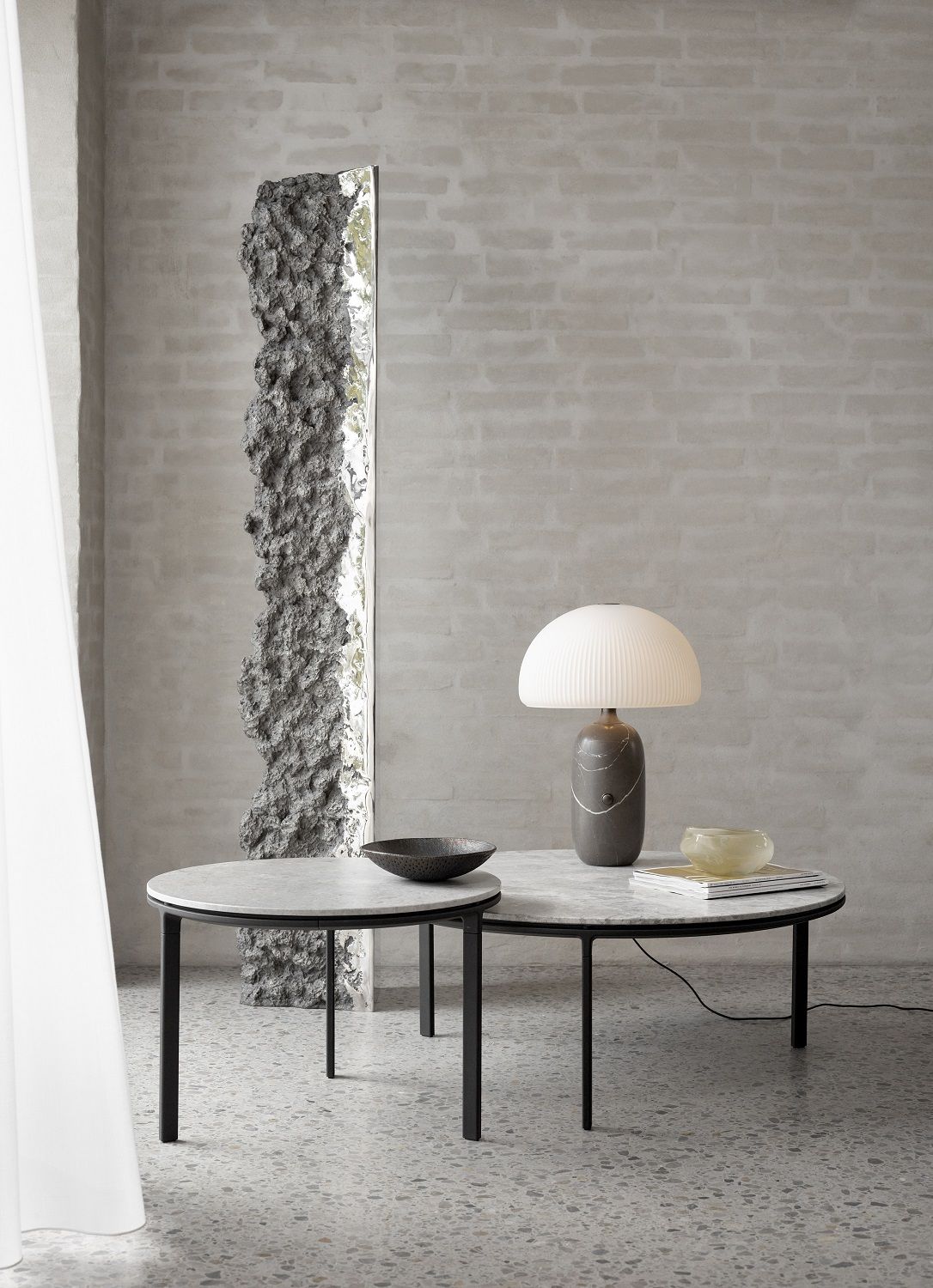 Zwei runde Couchtische von Vipp mit Marmorplatte und schwarzem Metallgestell im modernen Wohnzimmer.