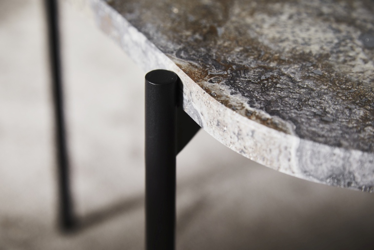 Detailaufnahme der Tischplatte des Woud Couchtischs mit schwarzem Metallfuß und marmorierter Oberfläche.