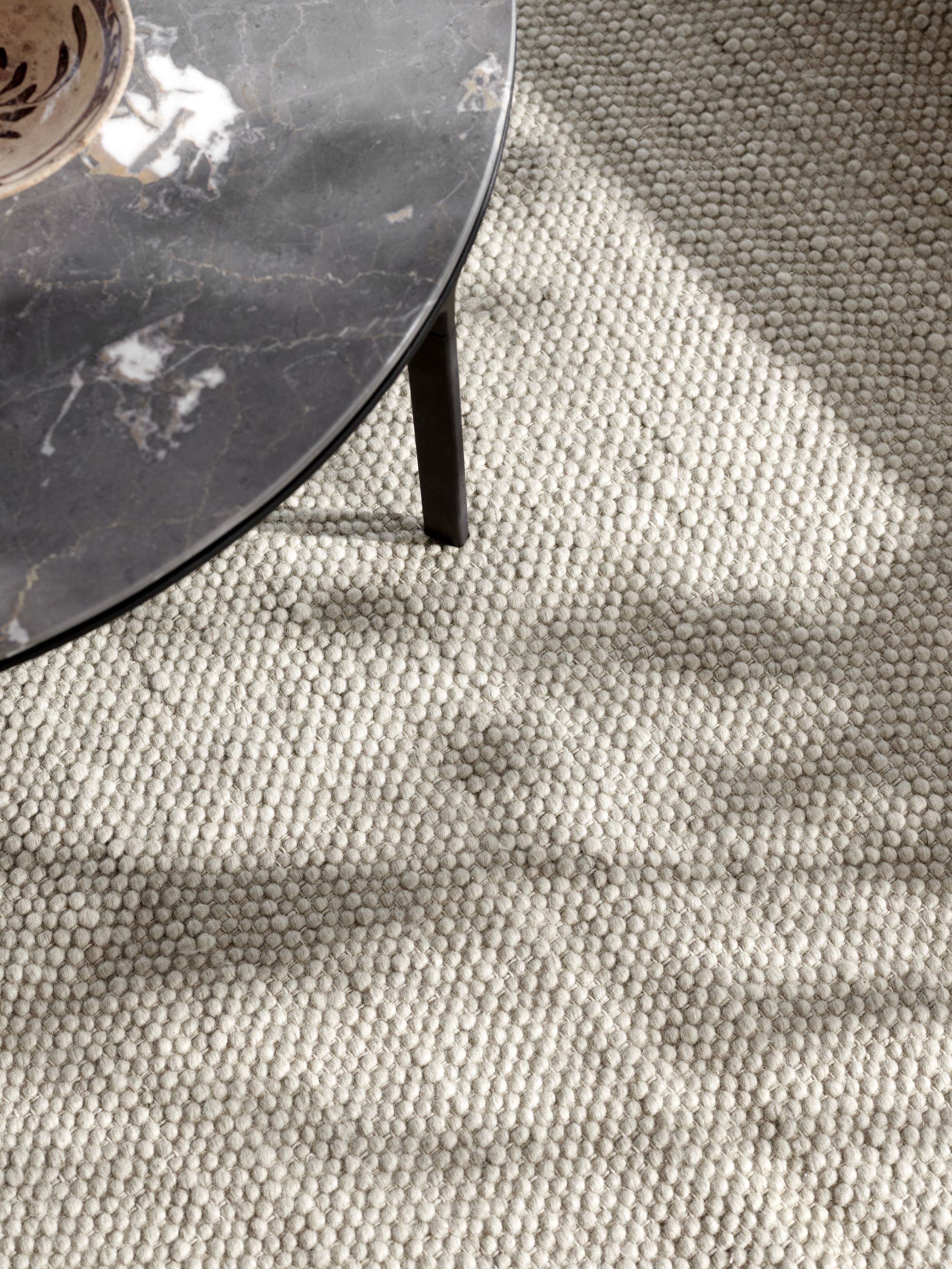 Detailaufnahme des Vipp  Wollteppichs in Beige, mit einer weichen, texturierten Oberfläche und einem modernen Design.