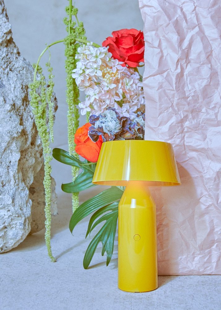 Gelbe Bicoca Tischleuchte von Marset, eine tragbare Akkuleuchte mit Blumen und Dekoration.