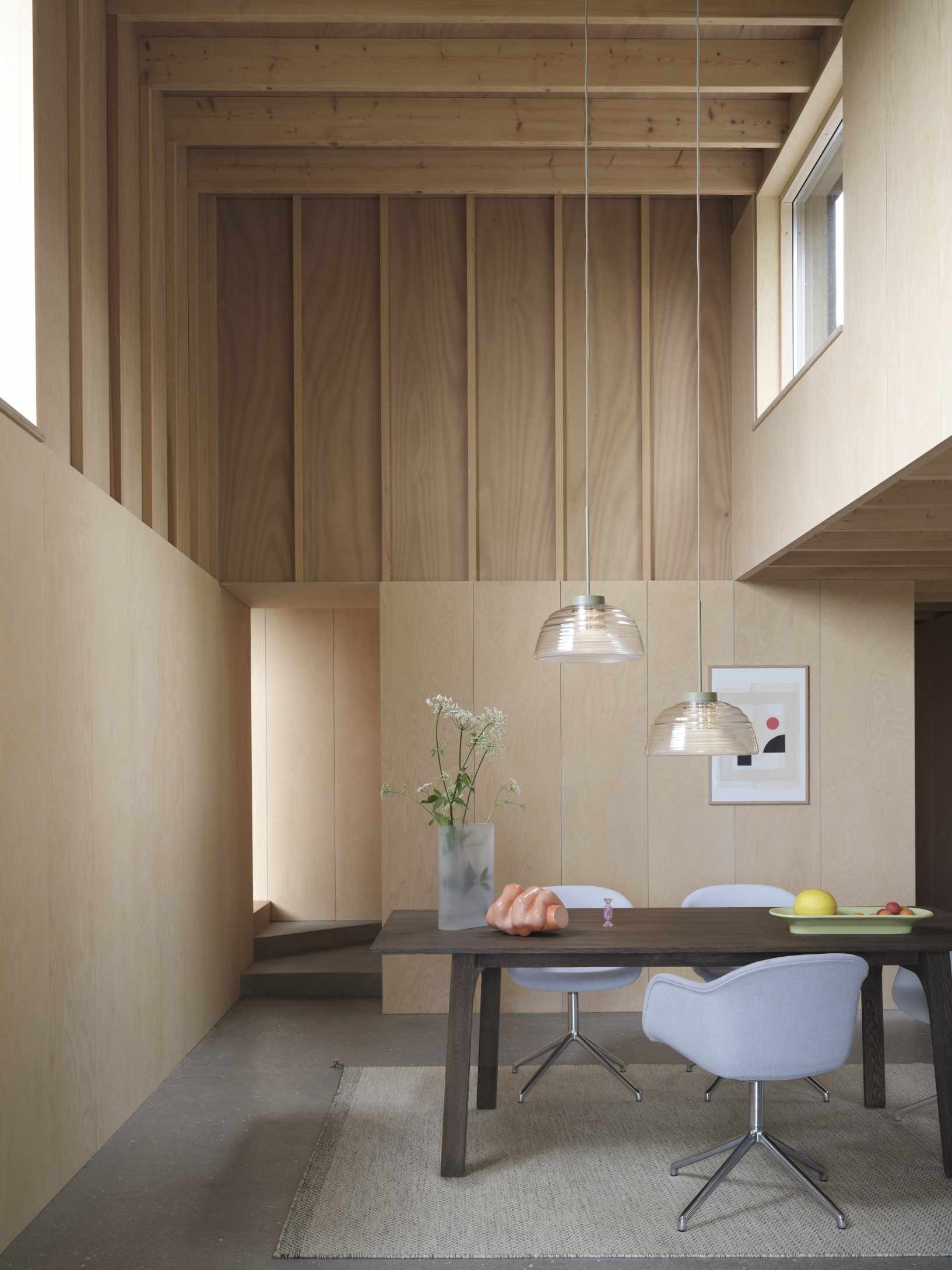 Muuto Ply Rug aus recyceltem Polyester in hellem Interieur mit Esstisch und Stühlen.
