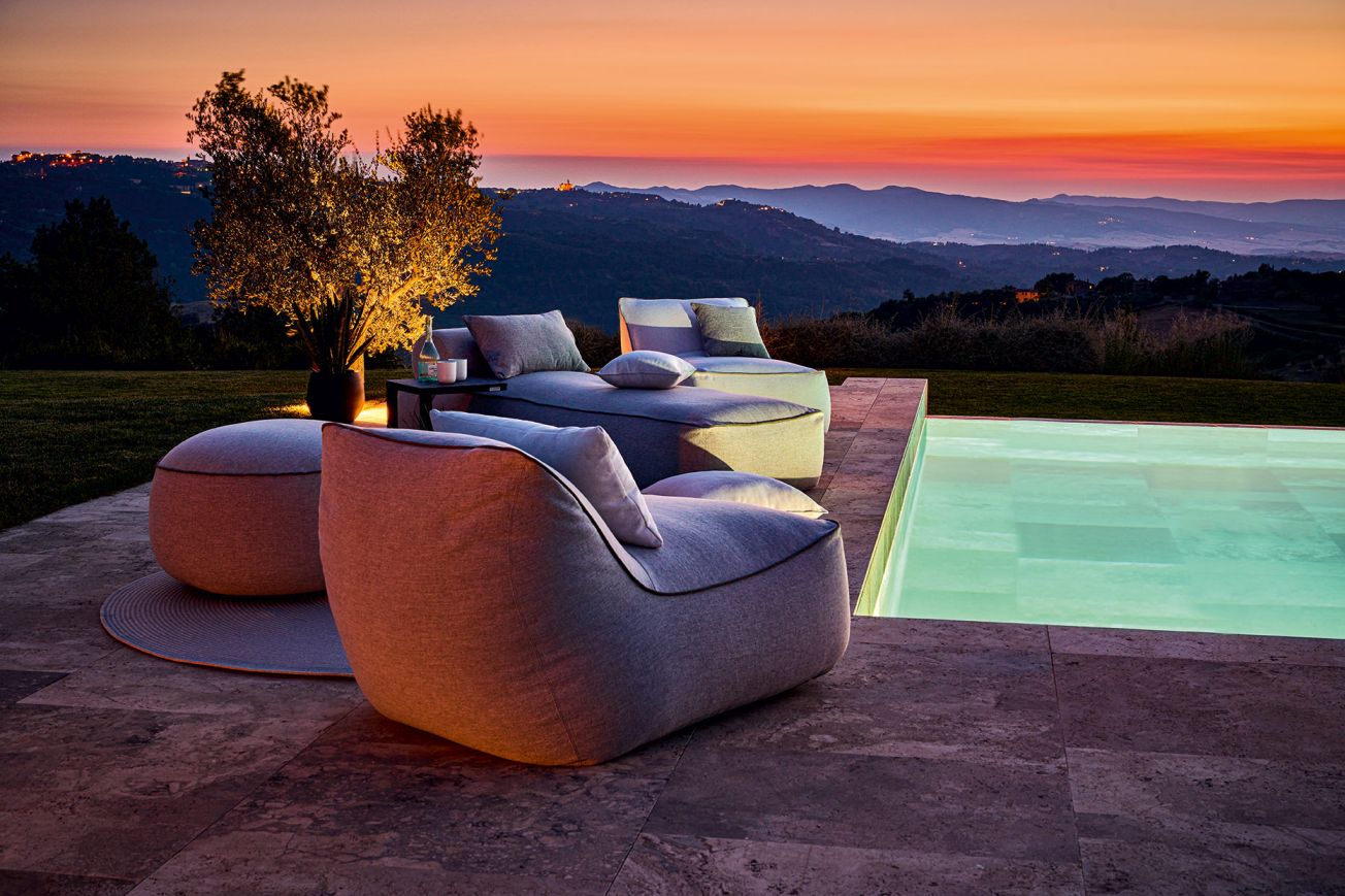 Maliha Lounge Hocker von Weishäupl, eckig, grau, Outdoor-Möbel am Pool bei Sonnenuntergang.