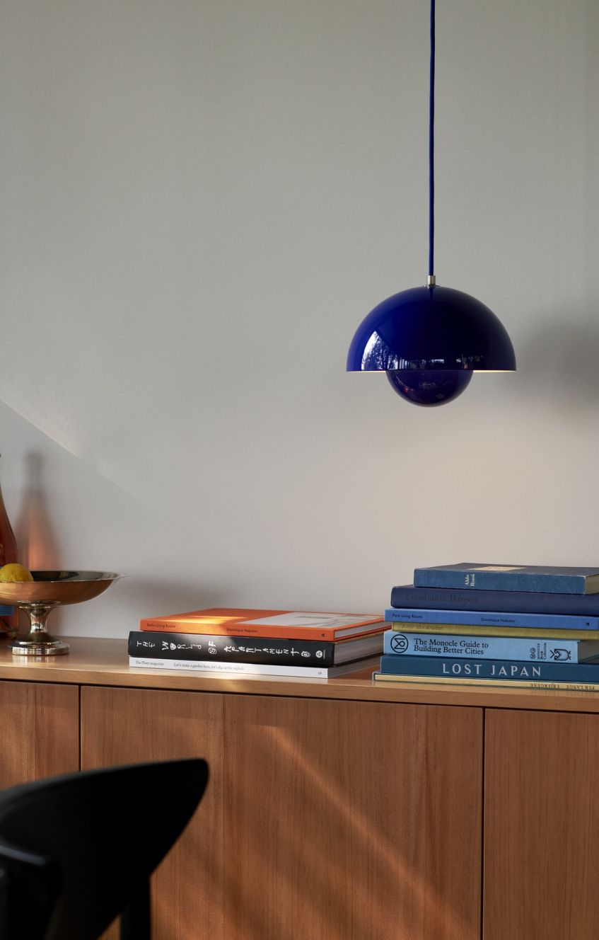 Blaue Flowerpot Pendelleuchte von Verner Panton über Bücherregal, moderne Hängelampe für Wohnzimmer und Esszimmer.