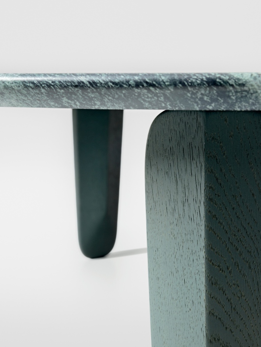 Detailaufnahme vom Kuyu Marble Couchtisch: Runde Marmorplatte und massive, farblich passende Holzbeine.