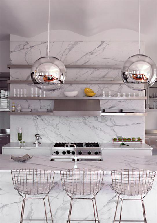Drei Bertoia Barhocker von Knoll International in einer modernen Küche mit Marmor-Arbeitsplatte und Pendelleuchten.