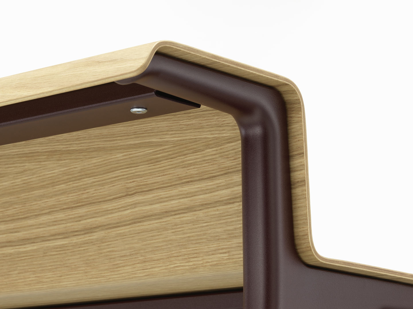 Detailaufnahme vom Vitra Courier Schreibtisch: Ecke der Tischplatte aus hellem Holz mit braunem Gestell.