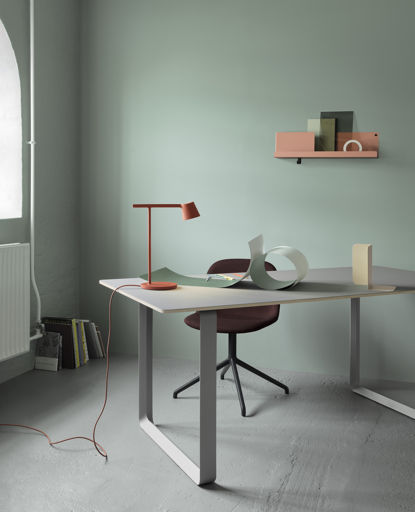 Muuto Fiber Side Chair mit Drehfuß in dunklem Rotbraun am Schreibtisch im modernen Büro.