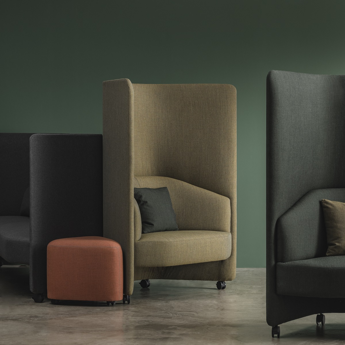 In Out Office Hocker RS2264 von Andreu World, orangefarbener Ottoman auf Rollen vor Loungesesseln.