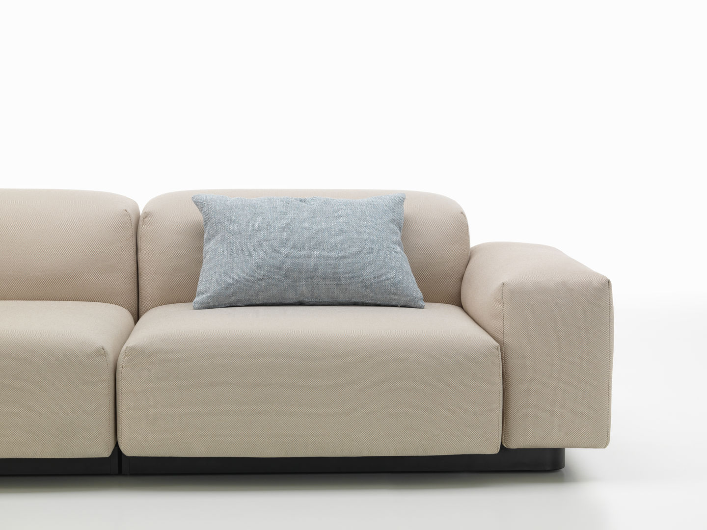 Vitra Kissen: Hellblaues Sofakissen auf einem beigen Sofa, modernes Design für Wohnzimmer und Lounge.