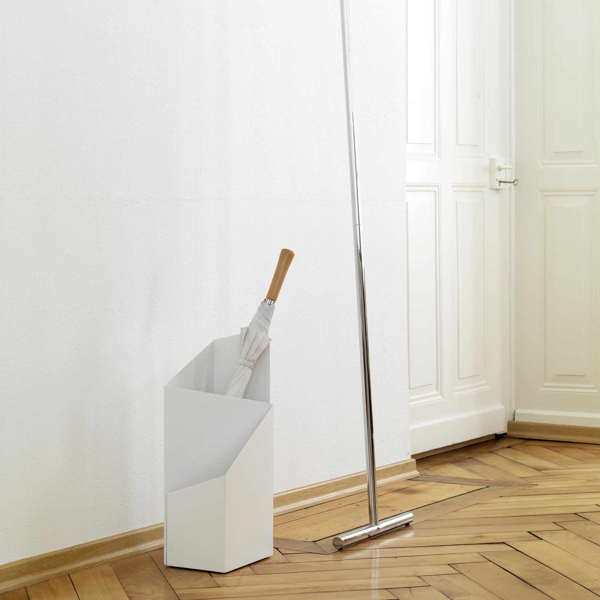 Weißer Via Schirmständer von Mox mit Regenschirm und Garderobenständer im minimalistischen Flur auf Parkettboden.
