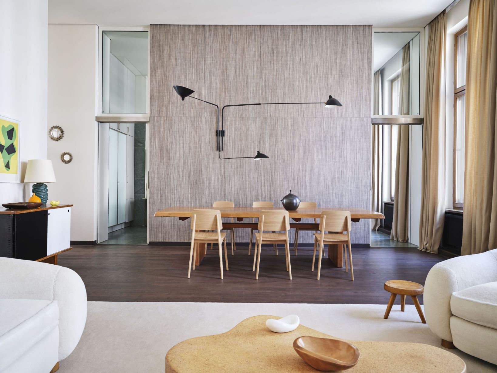 Helles Wohnzimmer mit Esstisch, Holzstühlen, moderner Lampe und stilvoller Dekoration für ein gemütliches Ambiente.