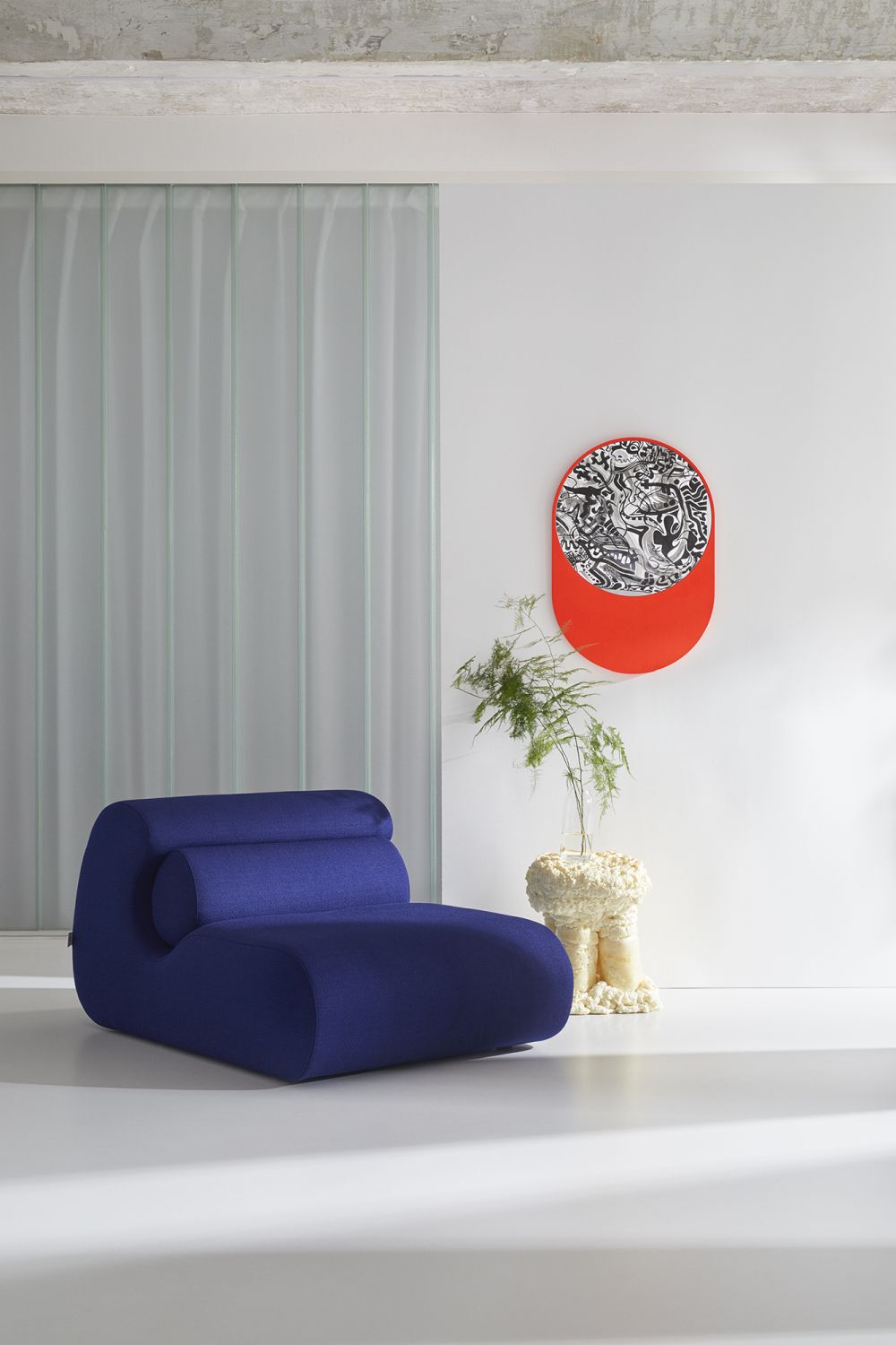 Blauer OLA Sofa Pouf OUT Sessel im modernen Interieur mit Kunstobjekt und Beistelltisch.