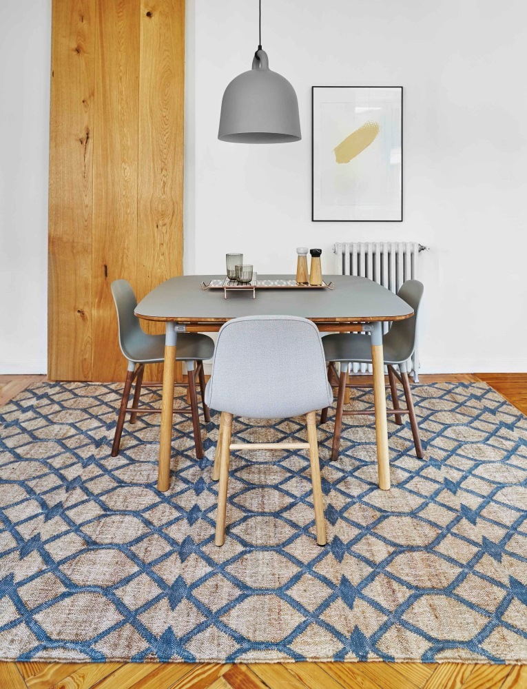 Detailaufnahme des GAN Kilim Rodas Teppichs 170x240 mit blauem geometrischen Muster unter einem Esstisch.