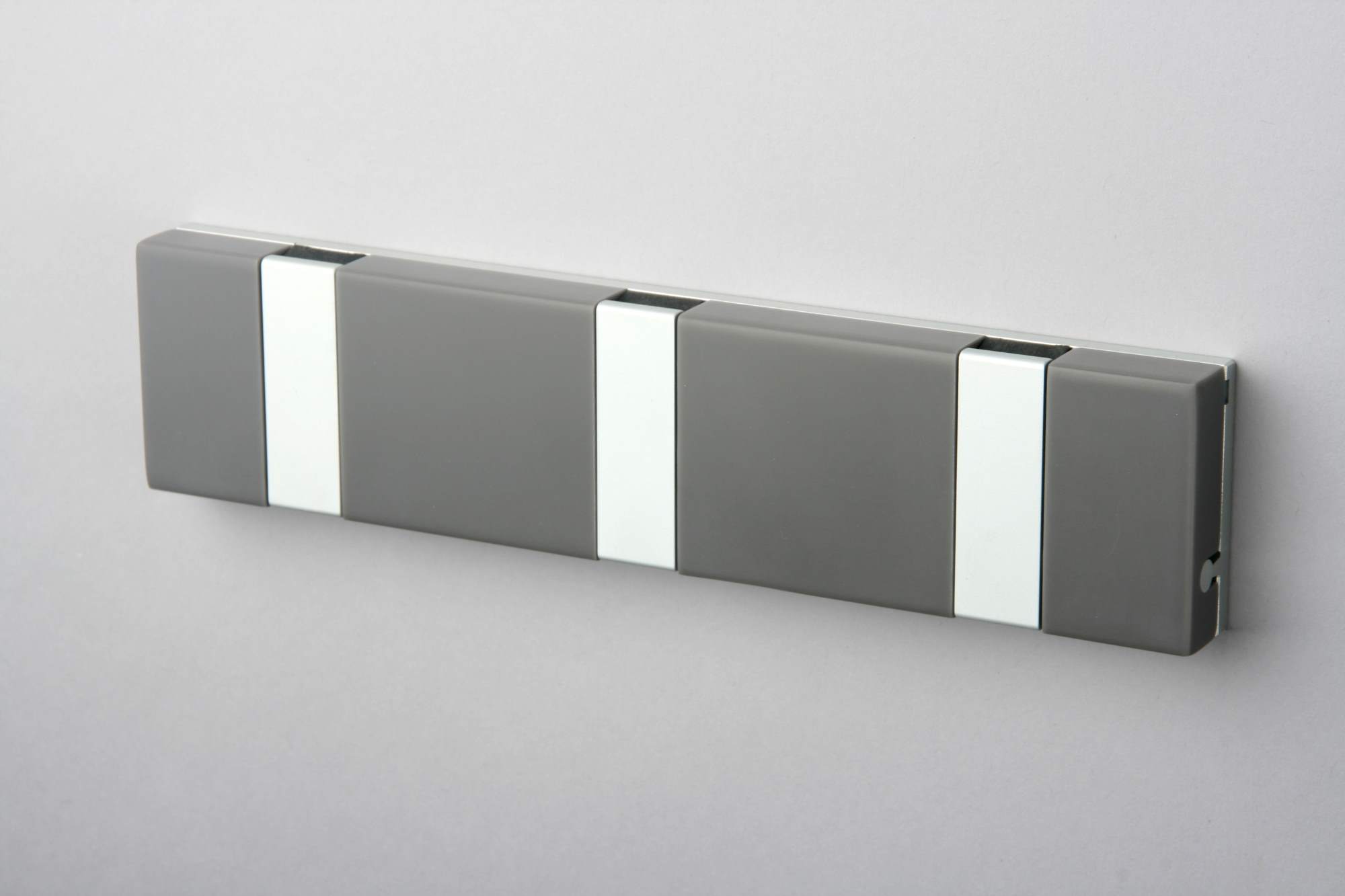 Graue Knax Lite Wandgarderobe mit drei Haken, waagerecht an einer Wand montiert. Moderne Garderobenleiste.