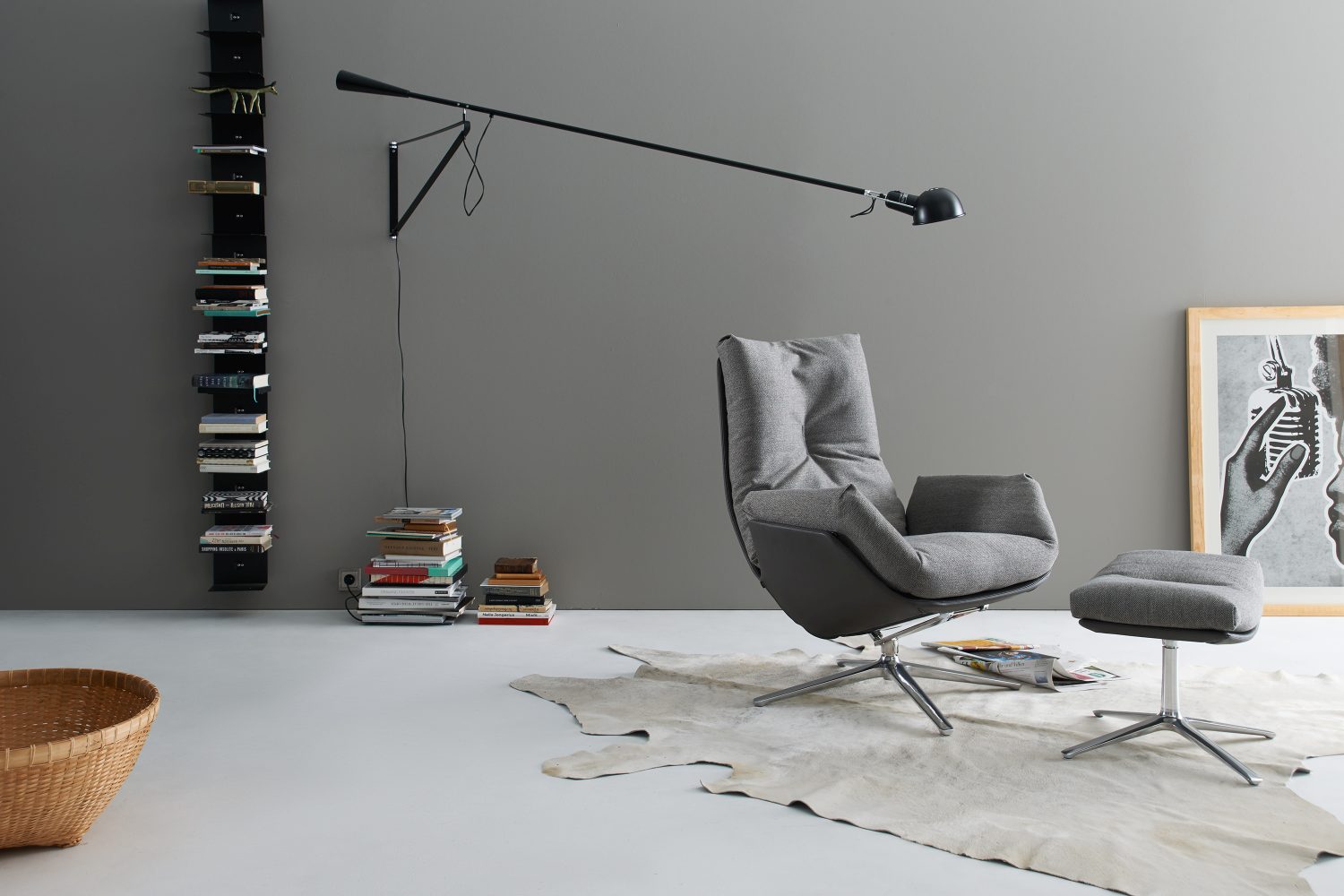 Grauer Cordia Sessel mit Hocker auf einem Fellteppich, modernes Wohnzimmer Interieur.