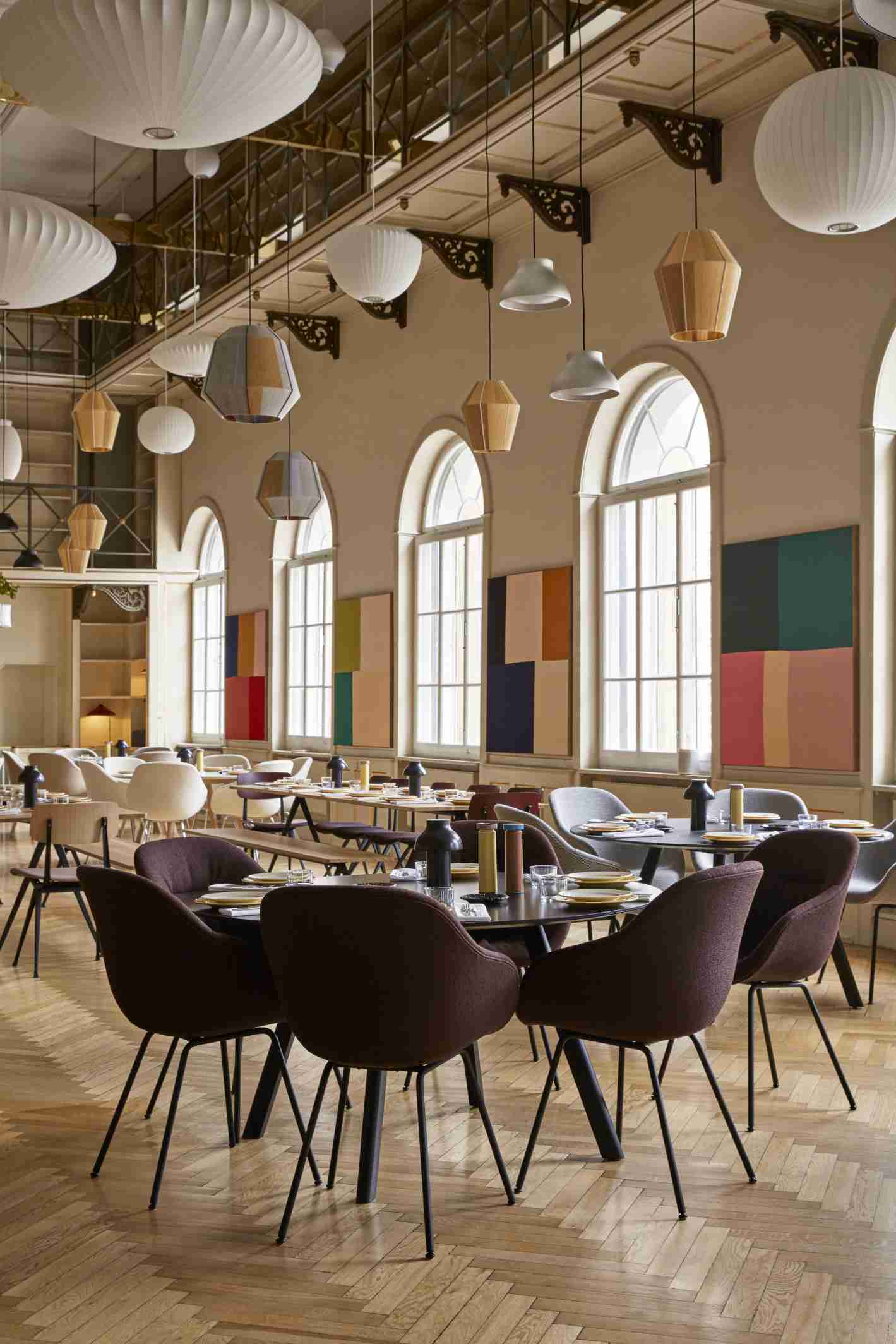 Innenaufnahme eines Restaurants mit mehreren Copenhague Table CPH 25 Tischen von Hay und passenden Stühlen.