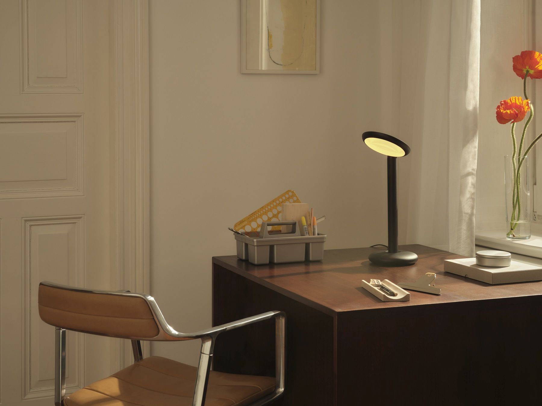 Graue Parrot Tischleuchte auf dunklem Holzschreibtisch, minimalistisches Design für Büro und Arbeitszimmer.