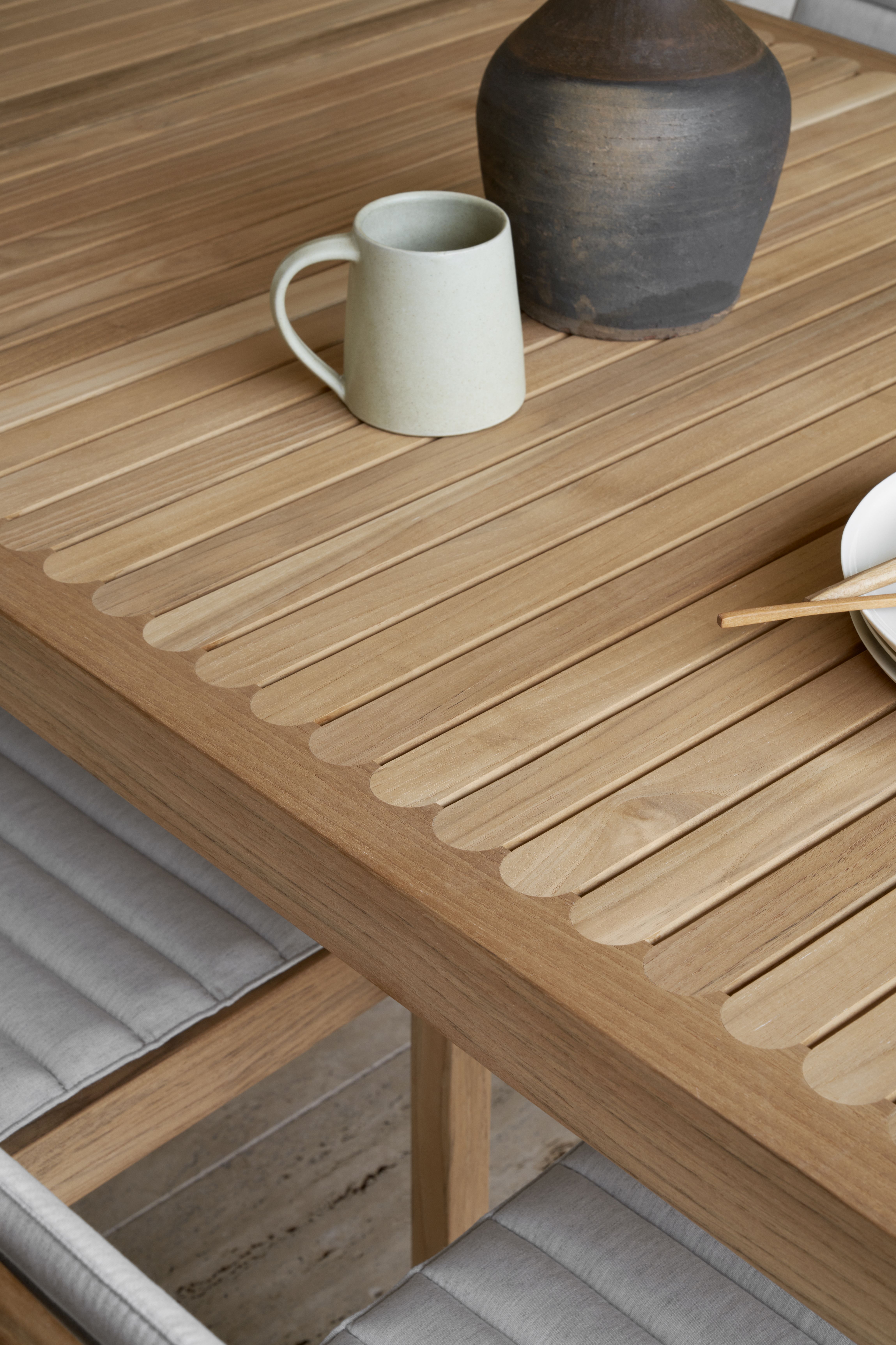 Detailansicht AH501 Teak Outdoor Stuhl von Carl Hansen & Søn mit Tasse und Vase.