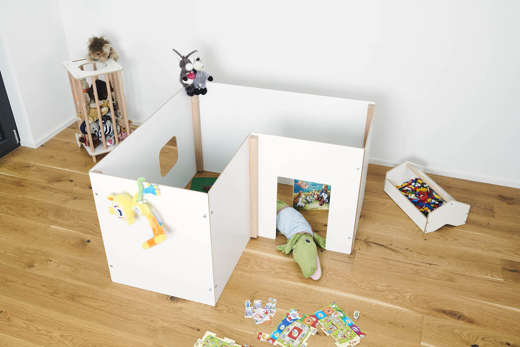 Tojo Kids Wand Spielewände: Weißes, modulares Spielhaus für Kinder mit Spielzeug auf Holzboden.
