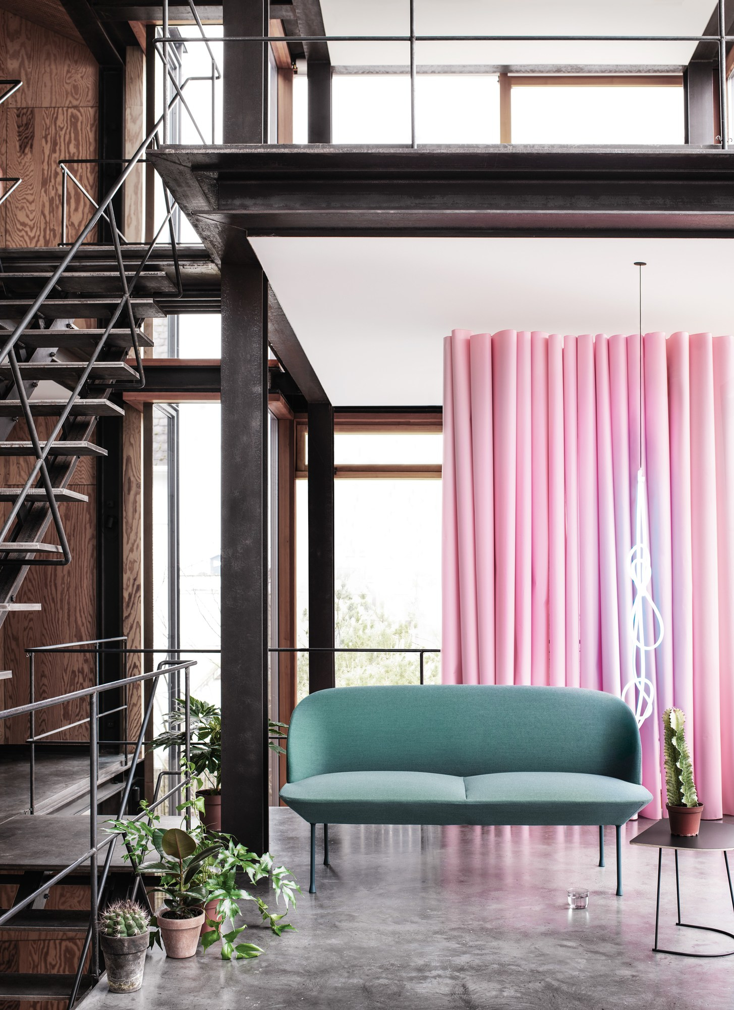 Türkisgrünes Muuto Oslo Sofa 2-Sitzer in modernem Loft mit rosa Hintergrund. Design Sofa für Wohnzimmer.